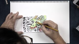 Hands drawing a dragon with Japanese calligraphy